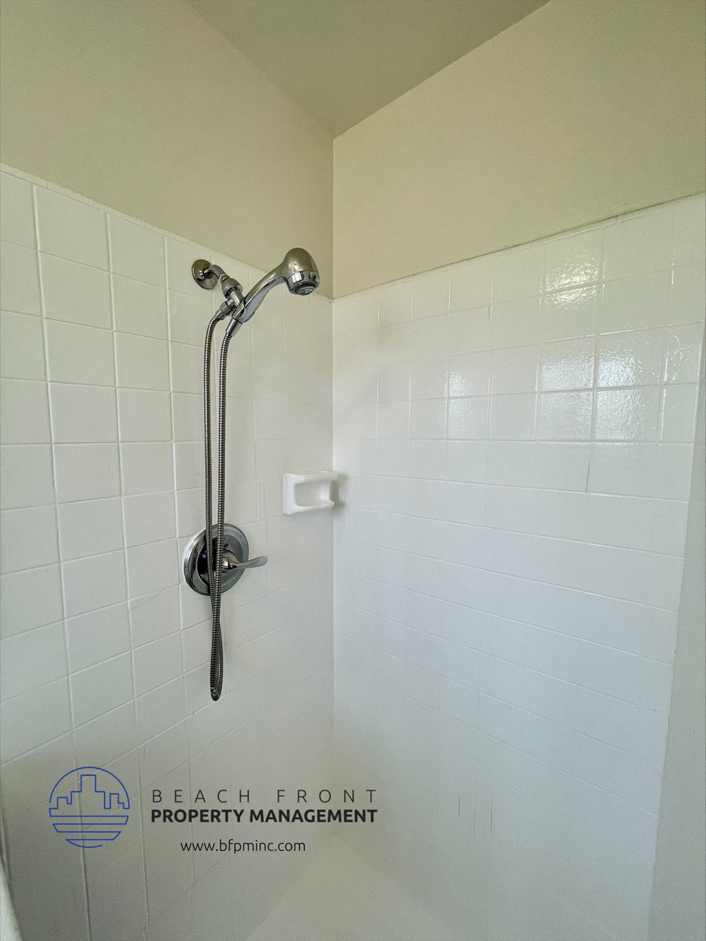 a white tiled shower in a white bathroom